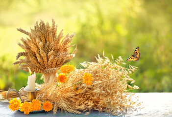 summer background. candlestick, calendula flowers and ripe ears of barley, wheat, oats on wooden...