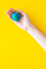 Fototapeta na wymiar Plasticine globe planet Earth in hand - protection ecology concept