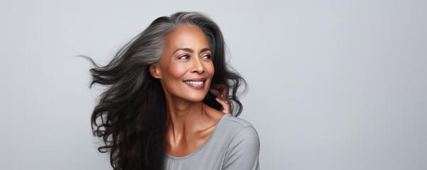Beautiful black woman with smooth healthy face skin. Gorgeous aging mature woman with long gray hair and happy smiling. Beauty and cosmetics skincare advertising concept. - obrazy, fototapety, plakaty