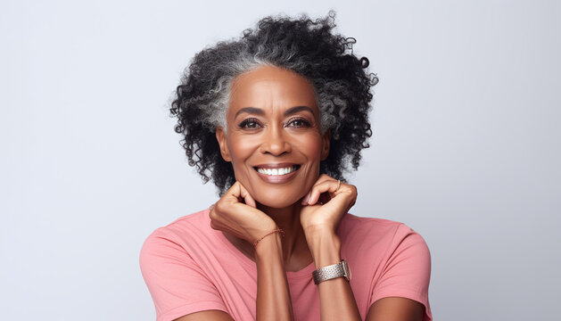 Smiling black adult woman touch face with smooth healthy skin. Open healthy smiling beautiful aging mature woman with white teeth. Beauty, dental and cosmetics skincare advertising concept.