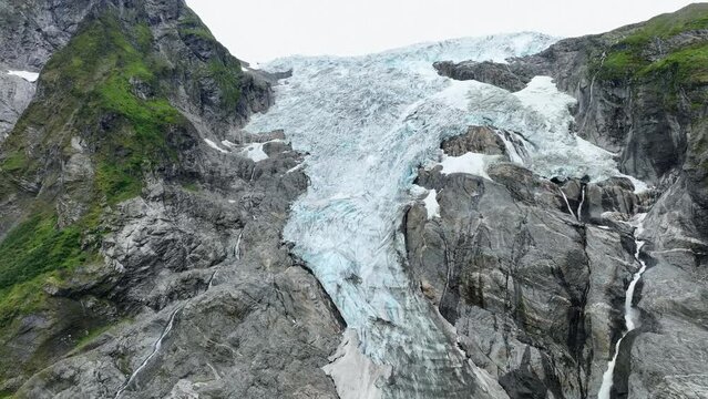 Boyabreen glacier full close up detail view with melting glacier water stream flowing down on right side - Aerial of Fjaerland part of the Jostedal Glacier Norway - 60 FPS