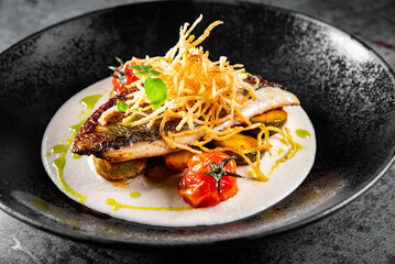 Fried fillet dorado fish with tomatoes, lemon and sauce on plate