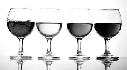 Glasses with wine on white background.Monochrome illustration of a number of drinks. A row of half-empty wine groceries. Four glasses with a variety of drinks.