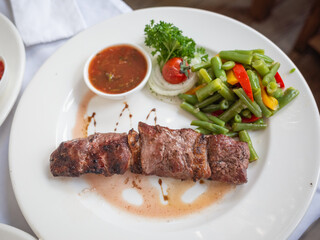 grilled juicy meat and mixed vegetableon the white plate in tatar restaurant in capital kyiv