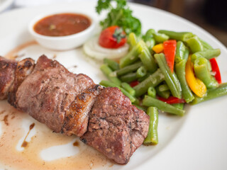 grilled juicy meat and mixed vegetableon the white plate in tatar restaurant in capital kyiv