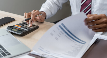 Fototapeta premium Businessman Accountant analyzing investment charts Invoice and pressing calculator buttons over documents. Accounting Bookkeeper Clerk&nbsp;Bank Advisor And Auditor Concept.