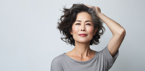 Japanese adult woman with smooth healthy face skin. Beautiful aging mature asian woman with long gray hair and happy smiling touch face. Beauty and cosmetics skincare advertising concept. - 633314780
