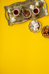 Bronze tray with Arabic or Turkish tea with sweets nuts and dried fruits, top view