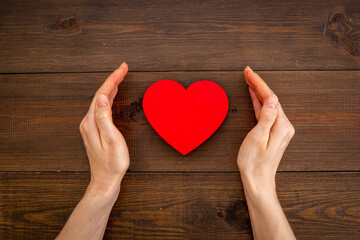 Medical and health care concept - heart with female hands