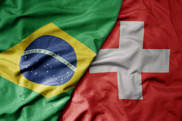 big waving realistic national colorful flag of brazil and national flag of switzerland .