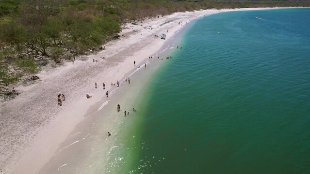 People On Sandy Beach Shore Of Popular Conchal Beach Costa Rica, 4K Drone Flyover