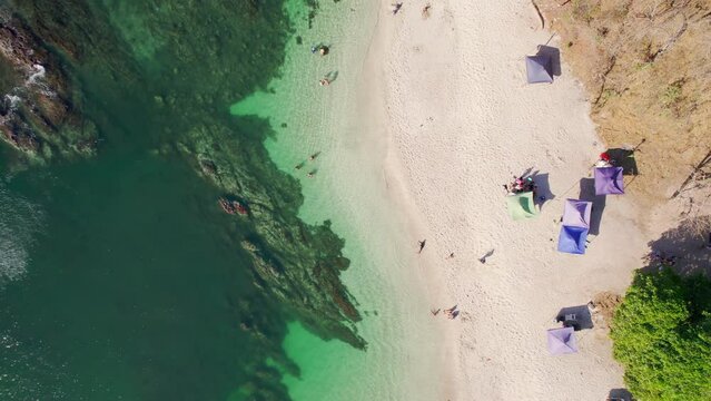 Top Down Birdseye Drone View Of People On Sandy White Beach Shore With Shade Tents And Clear Blue Ocean Water, 4K Costa Rica