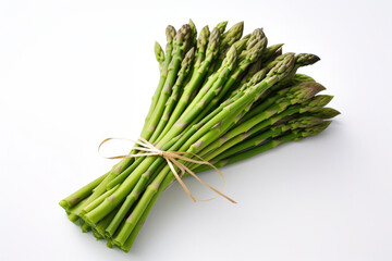 A bundle of fresh asparagus tied together with a white ribbon on a plain white background