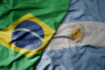big waving realistic national colorful flag of brazil and national flag of argentina .