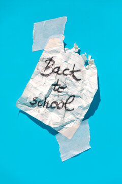 Note with message back to school pasted on blue wall