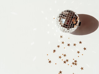 Minimal flat lay of Christmas or New Year, gold and silver party season decorations on white background.