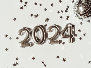 Greeting card - happy new year with numbers 2024 and silver star shape glitter on light background.