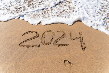 2024 hand written in sand on a beautiful beach