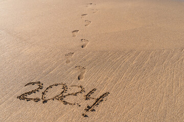 2024 hand written in sand on a beautiful beach