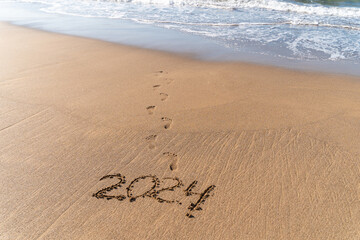 2024 hand written in sand on a beautiful beach