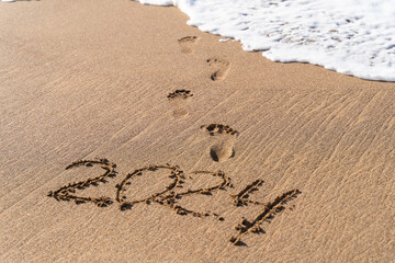 2024 hand written in sand on a beautiful beach