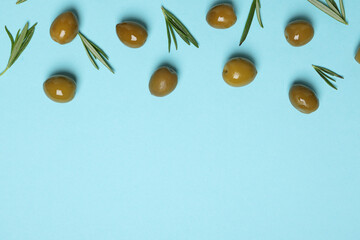Fototapeta premium Olives and leaves on blue background, space for text