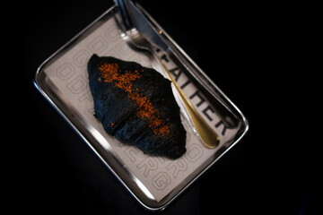 Charcoal croissants on a stainless steel plate