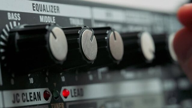 Man tuning knobs on guitar amplifier. 4k video footage UHD 3840x2160