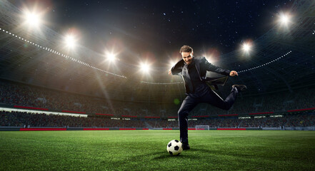 Emotional businessman hitting football ball on 3d arena with flashlights. Earning money during...