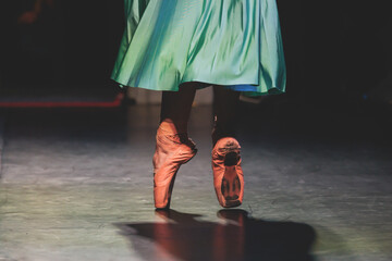 Ballet dancers couple during performance repetition, classic ballet rehearsal practicing in ballroom, view of legs in pointe shoes, ballerina and ballet dancer on a concert hall theatre stage © tsuguliev