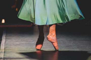 Ballet dancers couple during performance repetition, classic ballet rehearsal practicing in ballroom, view of legs in pointe shoes, ballerina and ballet dancer on a concert hall theatre stage © tsuguliev