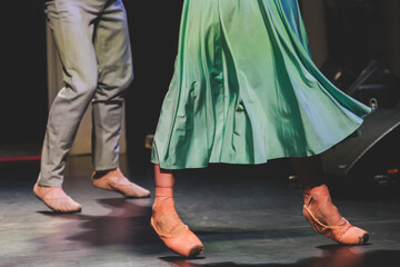 Ballet dancers couple during performance repetition, classic ballet rehearsal practicing in ballroom, view of legs in pointe shoes, ballerina and ballet dancer on a concert hall theatre stage © tsuguliev