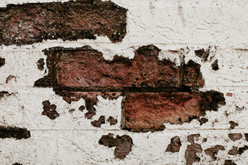 Cracked white grunge brick wall. Textured background, of white and red bricks, painted grungy rusty blocks.  Vintage damaged brick, pattern for design and interior. 