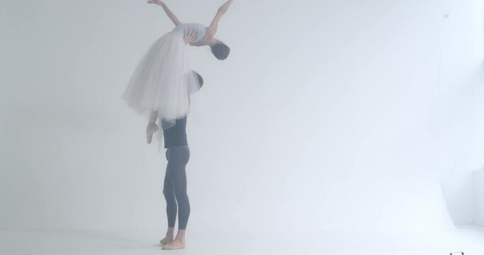 Dramatic, couple of classical ballet dancers rehearsing a dance, romantic dance of ballet dancers, a young couple engaged in choreography, haze effect.