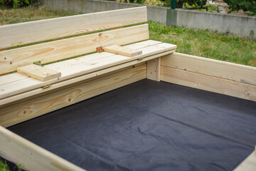 Homemade children´s sandbox, playground with a sand in the garden. Childhood concept. Europe, Czech Republic.