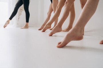 A group of girls doing gymnastics at the school are standing on tiptoe