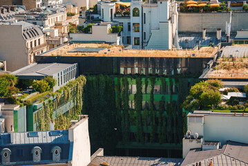 Aerial view of a large corporate office building with a green, triangular roof in a city setting.
