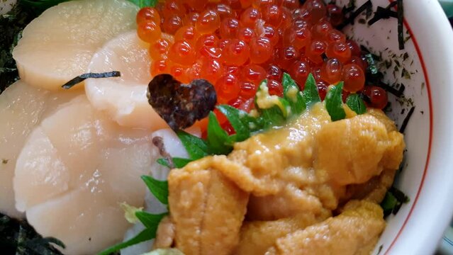 Hakkaido raw seafood rice topping scallop sea urchin and salmon roe hotate uni ikura Japanese food