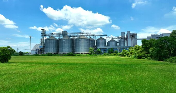 Plant for the drying and storage tank stainless silo grain. Rice plant in the middle of fields.