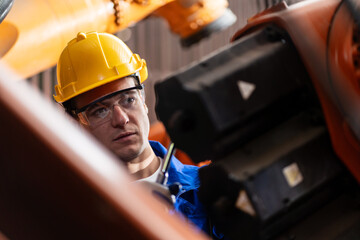 A team of engineers meeting to inspect computer-controlled steel welding robots. Plan for rehearsals and installation for use.