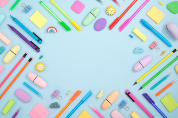 Frame of colorful school and office stationery set on cyan background. Flatly.
