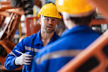 A team of engineers meeting to inspect computer-controlled steel welding robots. Plan for rehearsals and installation for use.