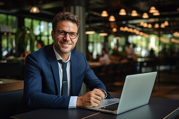 A handsome businessman in a suit and glasses in the office.
