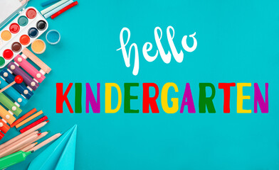 Hello kindergarten background. Top view flat lay concept. Childish lettering, colored paper, supplies, stationery for Pre-school, nursery school, kindergarten or preschool educational