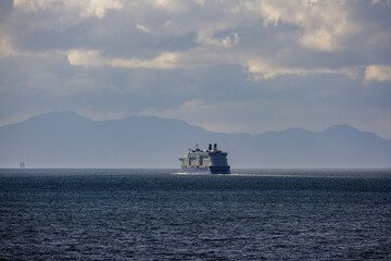 Breathtaking mountain glacier range view with luxury cruiseship cruise ship liner Silhouette sailing in front of Alaska mountains departure from Ketchikan with spectacular landscape scenery