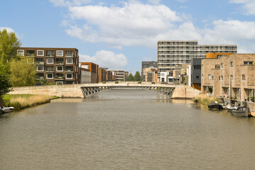 Obraz premium some buildings and boats on the water in front of a body of water that is brown with white clouds above it