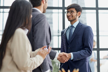 Group managers or employees standing in modern office hall after staff briefing and discussing corporate news