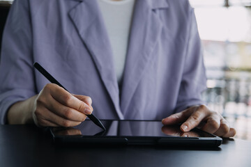 Asian Business woman using calculator and laptop for doing math finance on an office desk, tax, report, accounting, statistics, and analytical research concept