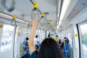 Woman hand firm grip safety handrail in elevated monorail train. Mass transit system in modern city. Inside of electric train. Tourist travel by city sky train. Public transportation. Urban transport.