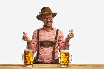 Happy man with mustaches wearing traditional german outfit with beer showing heart symbol, shape...
